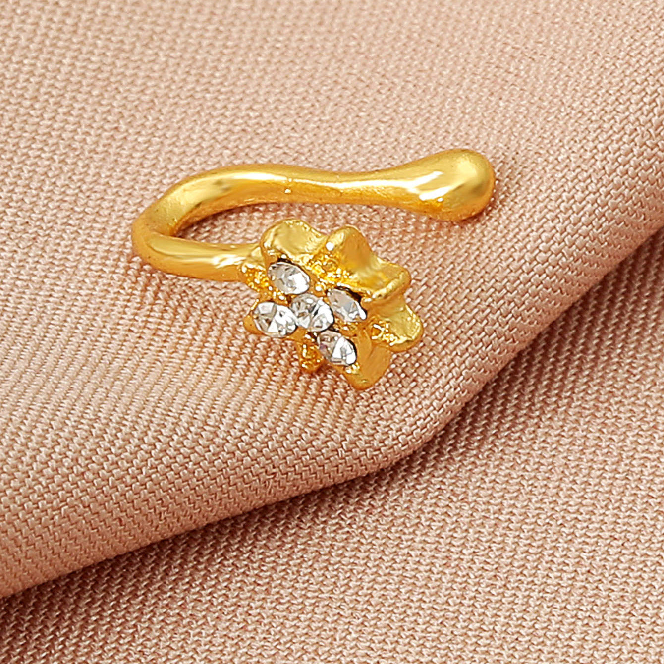 Zircon U-Shaped Leaves Heart Nose Studs with sparkling stones on a soft fabric background